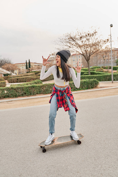 Young athlete riding a skateboard on the road. leisure and sport concept - Photo, Image