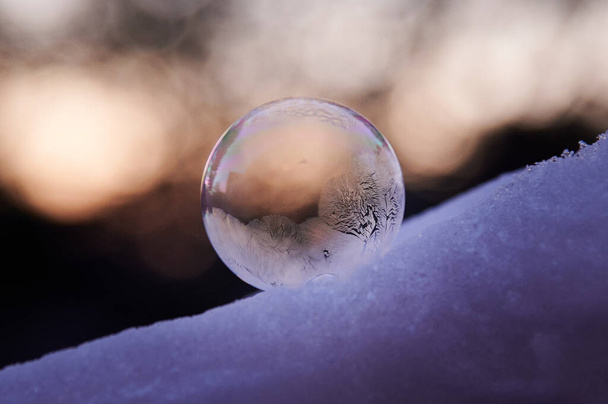 close up of a purple crystal ball on a snow background - Foto, Imagen