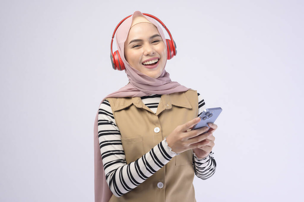 A young beautifu musliml woman wearing headset on white background - Valokuva, kuva