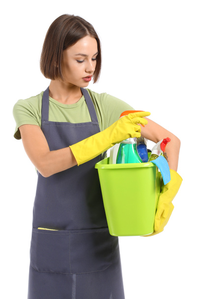 Όμορφη νεαρή γυναίκα με προμήθειες καθαρισμού σε λευκό φόντο - Φωτογραφία, εικόνα