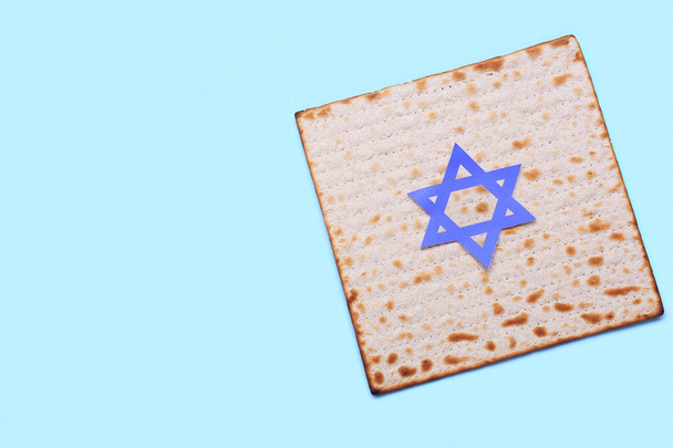 Jewish flatbread matza with David star for Passover on blue background - Photo, Image