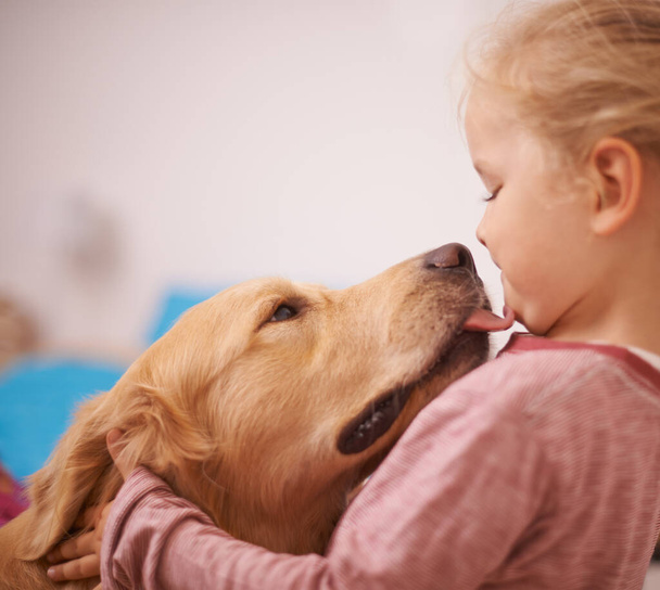 Kisses from my best friend. A cropped shot of a golden retriever licking a cute little girls face. - Foto, immagini