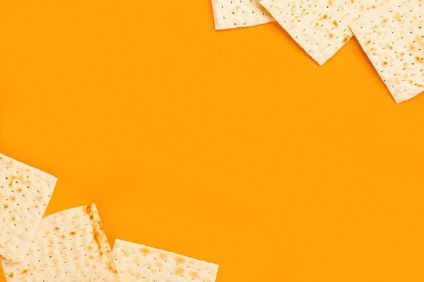 Frame made of Jewish flatbread matza for Passover on orange background - Фото, зображення