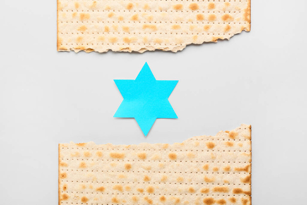 Revitty juutalainen flatbread matza pääsiäisenä paperilla David tähti kevyellä taustalla - Valokuva, kuva