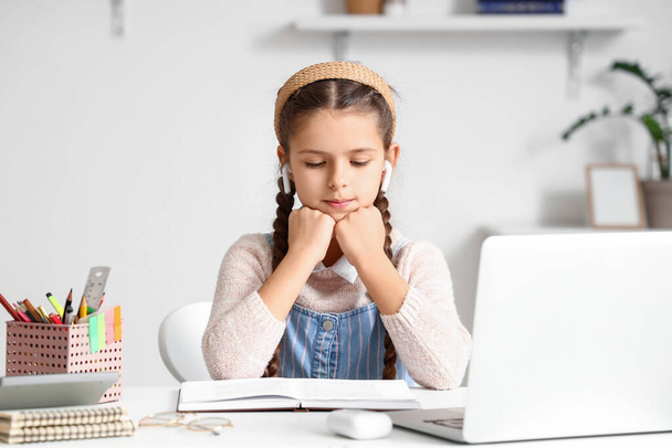 Κοριτσάκι σε ακουστικά που σπουδάζει Λογοτεχνία με online παιδαγωγό στο σπίτι - Φωτογραφία, εικόνα
