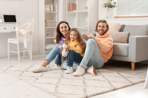 Junge Familie sitzt zu Hause auf weichem Teppich - Foto, Bild