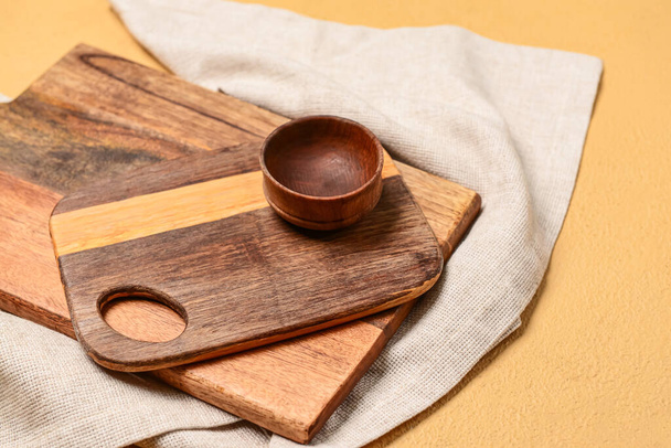 Drewniane deski do krojenia i miska na beżowym tle, zbliżenie - Zdjęcie, obraz