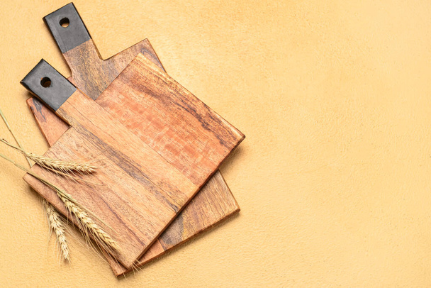 木製のまな板とベージュの背景にコムギのスパイク。 - 写真・画像