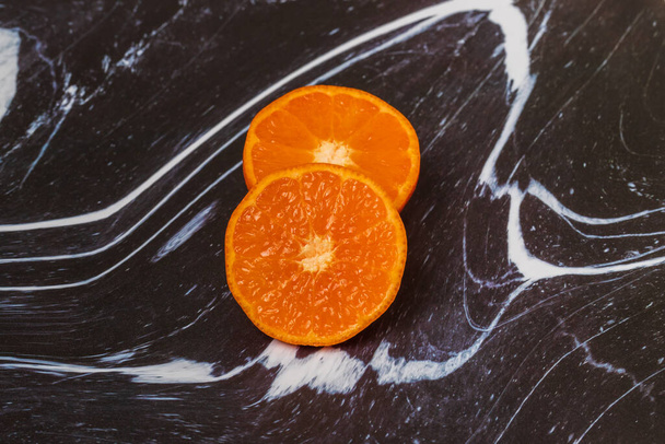 Roues de tangerine sur un fond sombre. Le fond est noir et blanc. - Photo, image