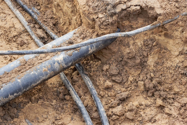 Vysokonapěťový elektrický kabel je umístěn v příkopu pod stávajícími inženýrskými kanalizačními sítěmi. Položení vysokonapěťového kabelu pro dodávky elektřiny do budov - Fotografie, Obrázek