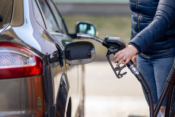 Process of refueling a car fill with petrol fuel at the gas station, pump filling fuel nozzle in fuel tank of car, high price of petrol and oil fuel, economic concept - Foto, Imagen