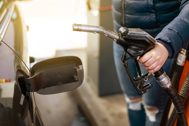 Process of refueling a car fill with petrol fuel at the gas station, pump filling fuel nozzle in fuel tank of car, high price of petrol and oil fuel, economic concept - 写真・画像