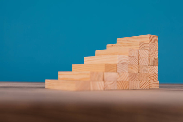 wooden cubes on a blue background. concept of success and growth. - Foto, Imagen