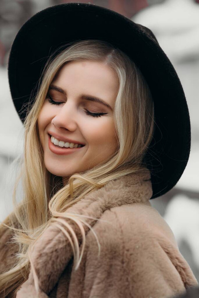 笑顔若い女性の帽子コート外花花束黄色喜びギフトブロンドモデル - 写真・画像