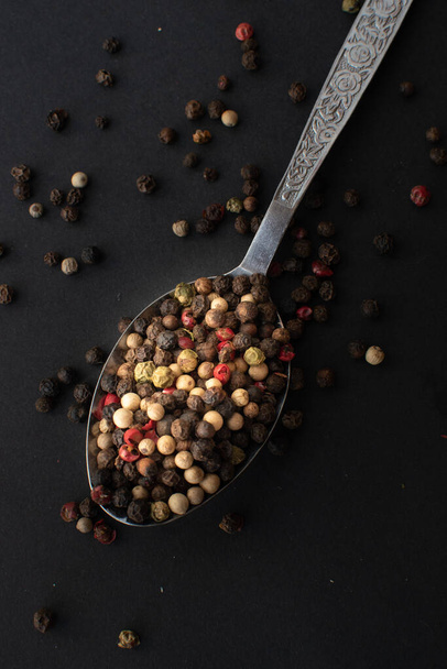 black pepper seeds in a spoon. top view. - Valokuva, kuva