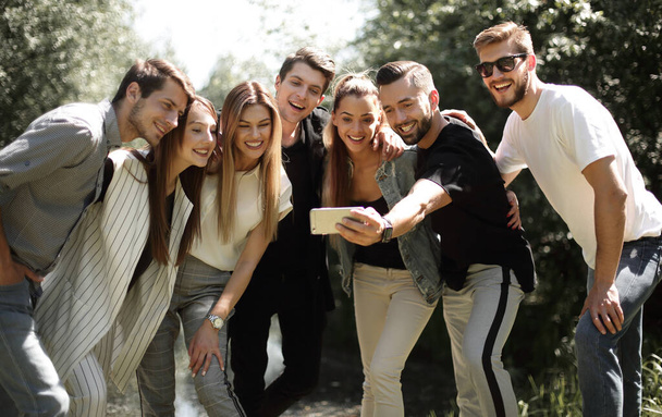 group of friends takes a selfie on the background of the city Park - Zdjęcie, obraz