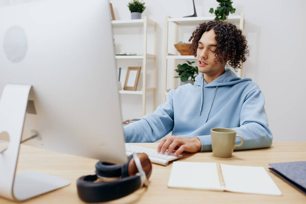 handsome guy sitting at a table in front of a computer freelance Lifestyle - Photo, Image