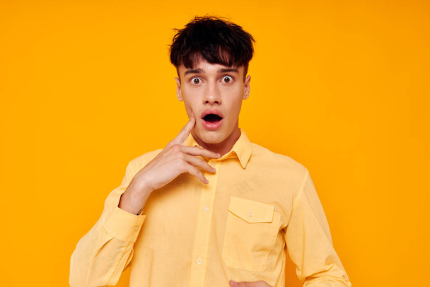 handsome man in yellow shirt posing emotions yellow background - Фото, изображение