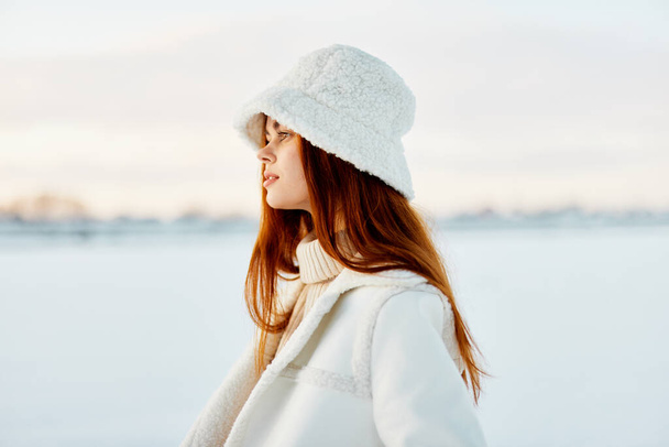 mooie vrouw rood haar sneeuw veld winter kleding Lifestyle - Foto, afbeelding