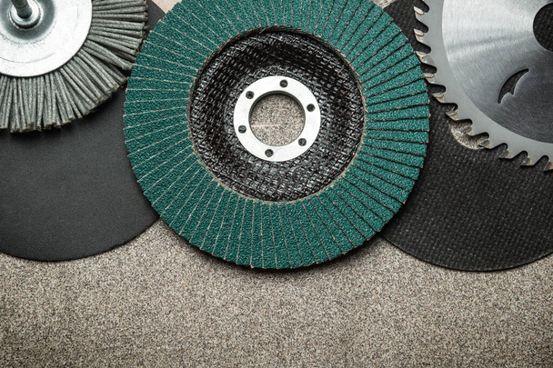 A large set of abrasive tools and grinding discs on the background of sandpaper. Tools used by master builders. - Photo, Image