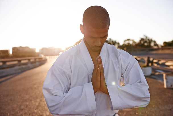 Suche nach Gelassenheit. Eine meditative junge Karate-Praktizierende trägt einen Gi. - Foto, Bild