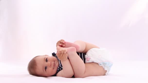 Piccolo bambino che gioca con i piedi contro sfondo bianco
 - Filmati, video