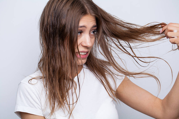 Jovem aplicando óleo essencial orgânico natural no cabelo - Foto, Imagem