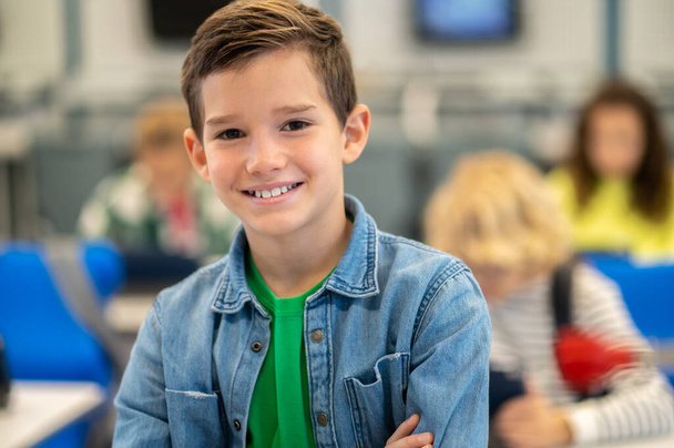 Boy smiling confidently at camera in class - Фото, зображення