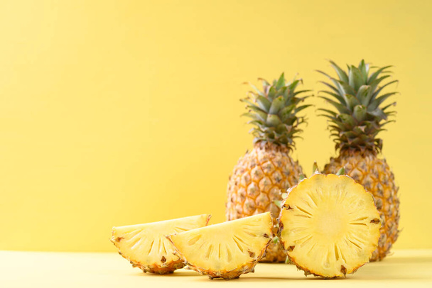 Frische Ananasfrüchte auf gelbem Hintergrund, tropische Früchte - Foto, Bild