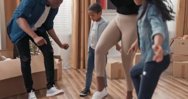 A happy family dances in the middle of the living room young parents and their children celebrate moving into a new apartment rejoice together practice choreography - Materiał filmowy, wideo