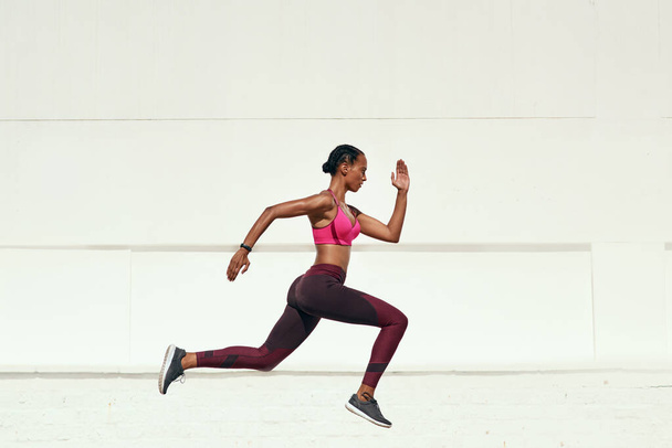 Whether you go slow or fast, just go. Shot of a sporty young woman out running. - Foto, Imagen