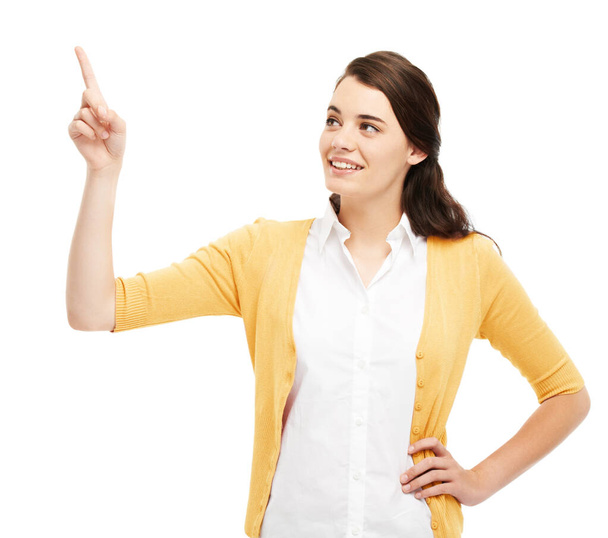 Pointing towards the answer. Attractive young woman pointing upwards against a white background. - Foto, afbeelding