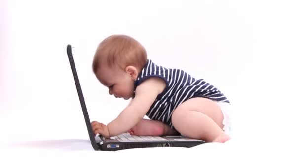 Menino brincando com um laptop, tablet, mouse, teclado contra fundo branco
 - Filmagem, Vídeo