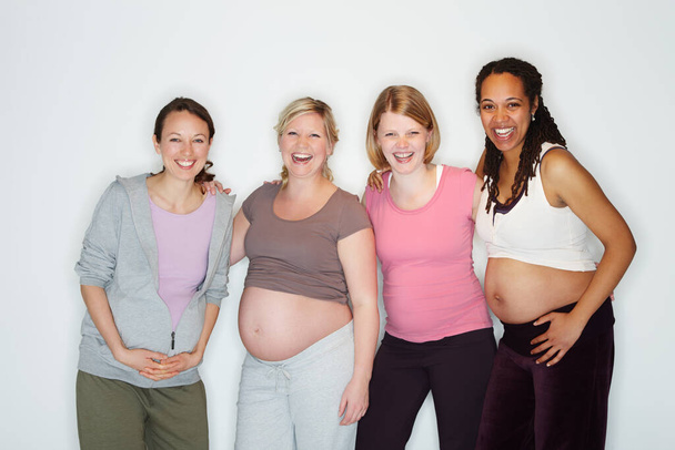 Η εγκυμοσύνη είναι χαρά γι 'αυτούς. Έγκυοι φίλοι στέκονται μαζί ενώ απομονώνονται σε λευκό. - Φωτογραφία, εικόνα