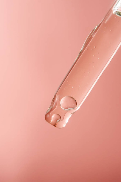 Pipette with cosmetic product in water with bubbles. - Foto, Imagen