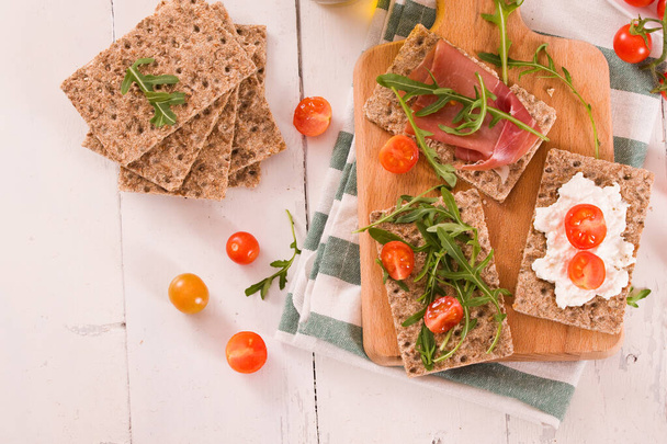 Crispy rye bread with sesame seeds, ham and cottage cheese. - Foto, afbeelding