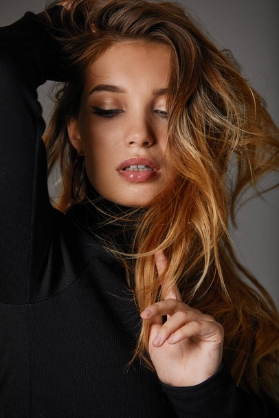 Divat portré szép modell nő hosszú egészséges haj fekete ruhában szürke háttér, gyönyörű arc profil - Fotó, kép