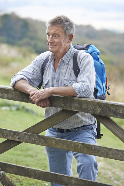 Senior Man Hiking In Countryside Resting By Gate - Photo, image
