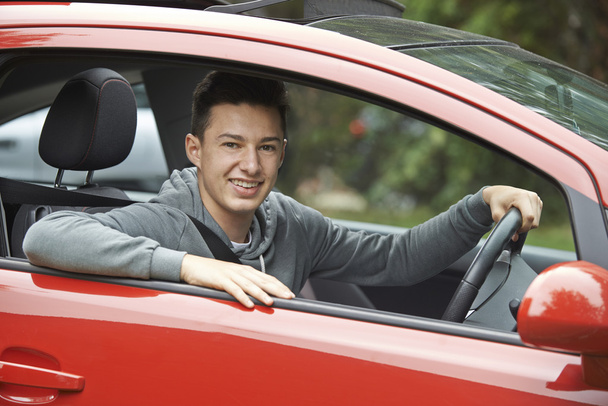 Newly Qualified Teenage Boy Driver Sitting In Car - 写真・画像