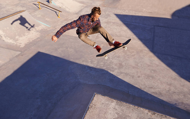 Une belle journée au skate park. Un jeune homme fait des tours sur son skateboard au skate park. - Photo, image