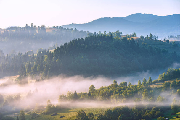 Majestic view of alpine village covered with blue fog in a light of sunrise. Early morning scene, beauty misty image, fantastic landscape. Carpathians, Ukraine. - Zdjęcie, obraz