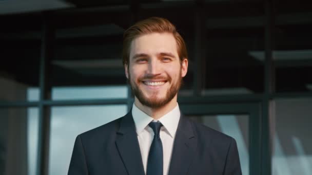 Young businessman smiling and looking at camera. Young man in a suit in the office - Footage, Video