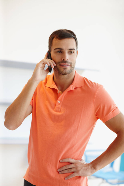 Taking a quick call. A casual young businessman taking a phone call. - Photo, Image