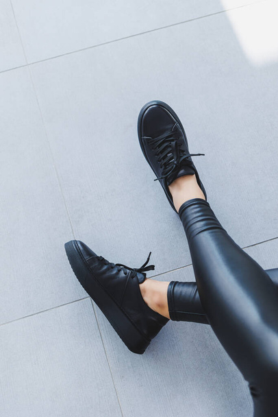 新しいコレクションの女性の革の靴、女性の足は黒のレースアップスニーカーでクローズアップ。春と夏の靴 - 写真・画像