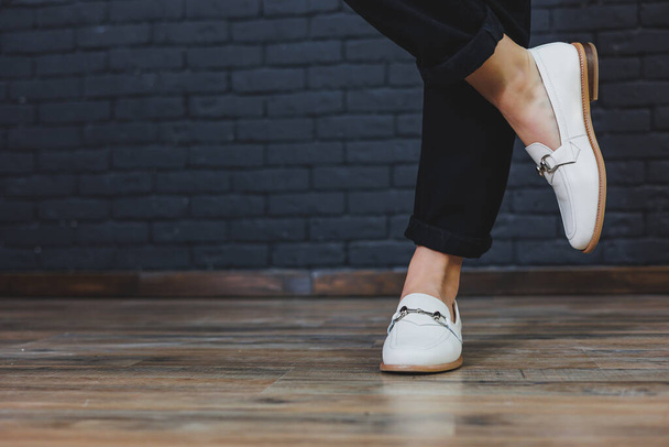 Lähikuva naisten jalat mustat housut ja nahka beige mokkasiinit. Uusi kevät-kesä kokoelma naisten nahkakengät 2022 - Valokuva, kuva