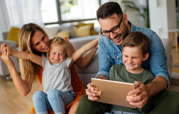 Digital device technology family online education concept. Happy young family with digital devices at home. - Фото, изображение
