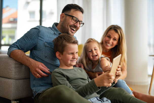 Digital device technology family online education concept. Happy young family with digital devices at home. - Photo, image