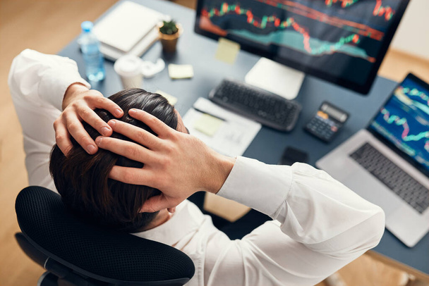 Worried businessman looking at charts stressed by news from stock market. Investor lost money online. Man analyses loss and profit. Businessman investing stocks online. Man working with stock chart data. Business investing trouble concept - Photo, image