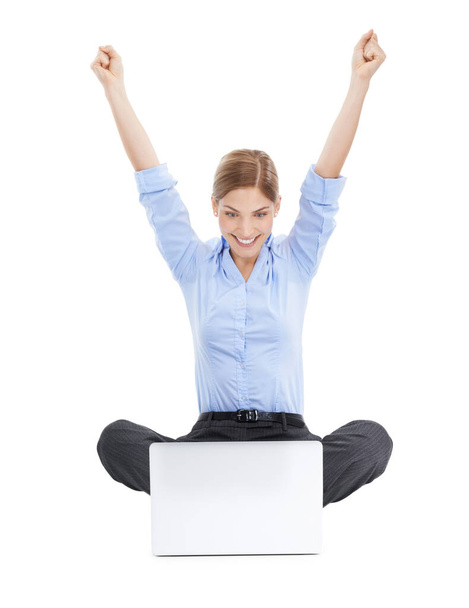 Better than ever before. Studio shot of a young businesswoman using her laptop on the floor and cheering in success against a white background. - Foto, Imagen