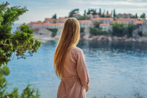 Woman tourist on background of beautiful view of the island of St. Stephen, Sveti Stefan on the Budva Riviera, Budva, Montenegro. Travel to Montenegro concept - Foto, Imagem